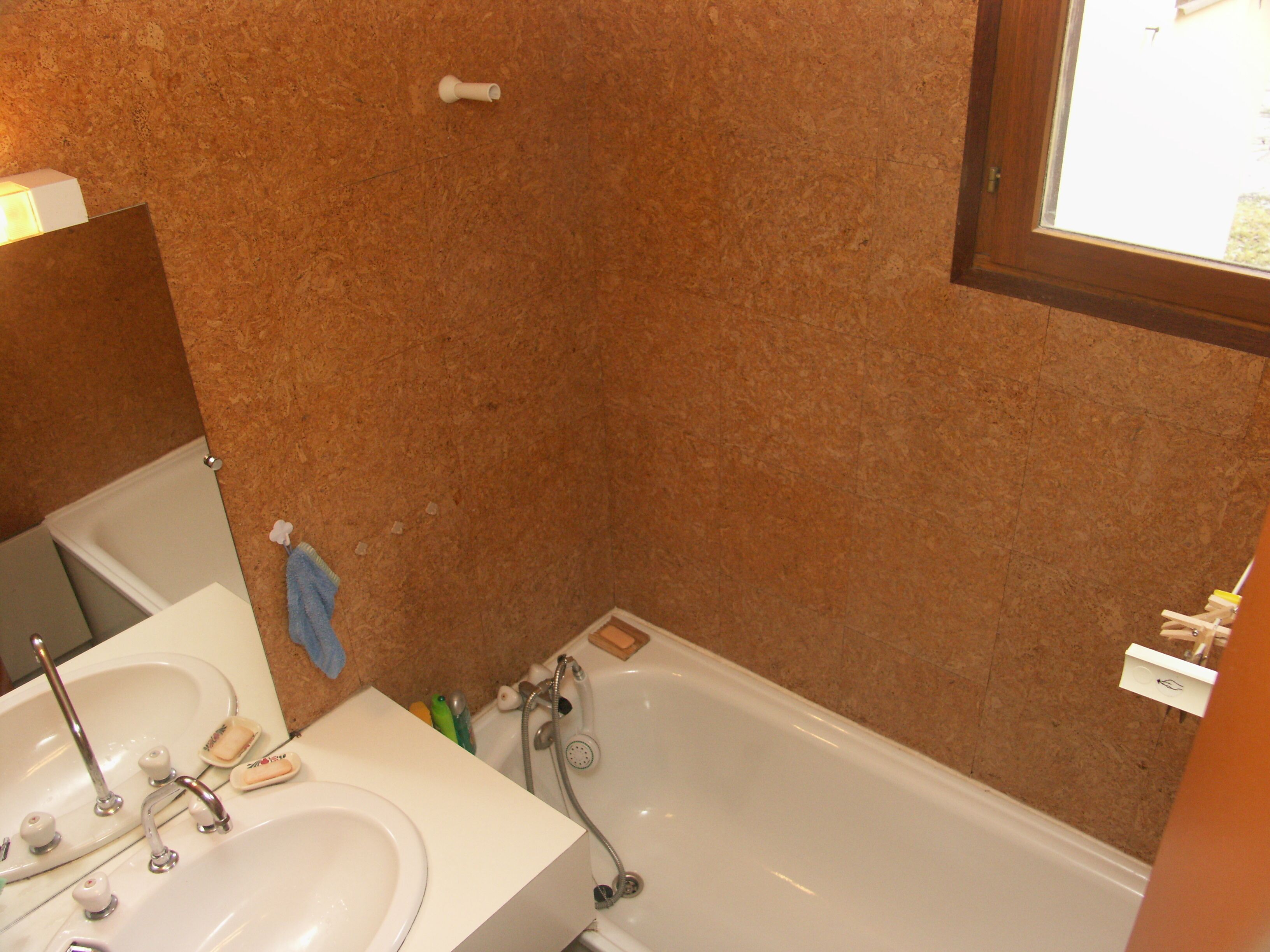 A bathroom with a sink, mirror, and bathtub.