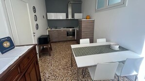 Una cocina compacta con comedor, una mesa blanca y sillas.