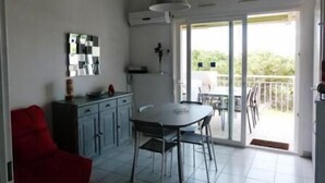 Une cuisine moderne avec un coin repas, une chaise rouge et un balcon avec vue.