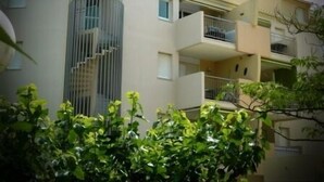 Un immeuble résidentiel à plusieurs étages, doté de balcons et d’un escalier central.