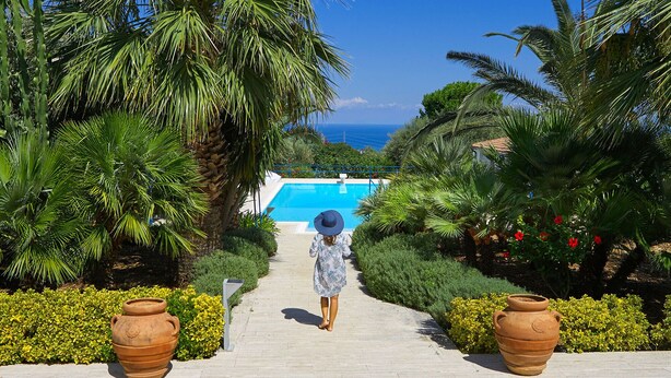 A pathway leading to a pool with a view of the sea, surrounded by lush greenery and large terracotta pots. - Blue House with pool. Paradise between sky and sea  (Trabia)