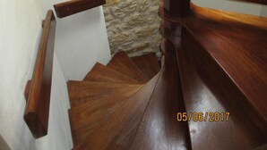 A wooden staircase with a stone wall background. -  Charming riverside stone built  property in Perigord (La Roque-Gageac)