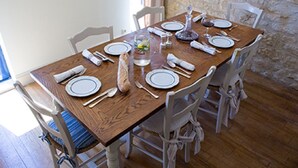 A wooden dining table set with plates, cutlery, and a glass of water. -  Charming riverside stone built  property in Perigord (La Roque-Gageac)