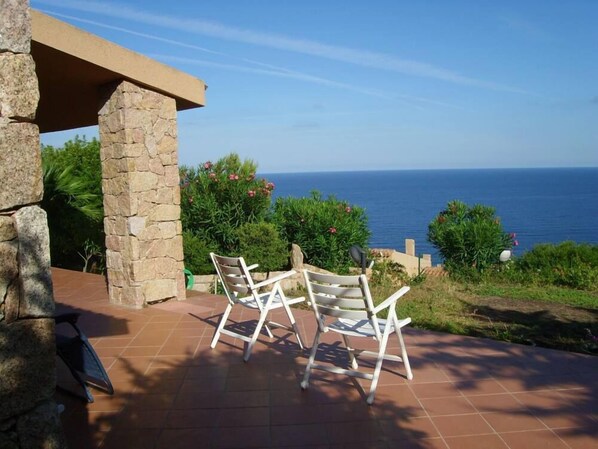Un patio con muros de piedra y vistas al mar.