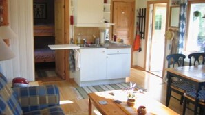 Een compacte woonruimte met een kitchenette, een eethoek en een bank.