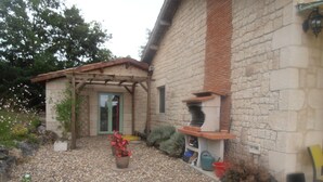 A stone building with a garden area, a pergola, and a barbecue structure. - House / Villa - Sainte sabine (Beaumontois En Périgord)