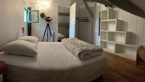A bedroom with a bed, a tripod lamp, a mirror, and a white wardrobe. - House / Villa - Sainte sabine (Beaumontois En Périgord)