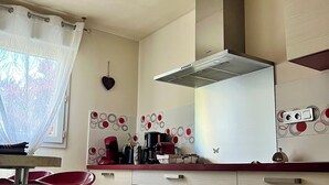 A modern kitchen with white cabinets, a stainless steel range hood, and a red countertop. - House / Villa - LA BAULE-ESCOUBLAC (La Baule-Escoublac)