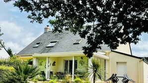A house with a sloped roof, a covered porch, and a stone retaining wall with plants. - House / Villa - LA BAULE-ESCOUBLAC (La Baule-Escoublac)