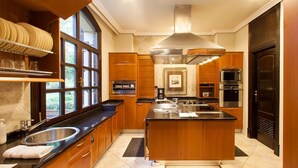 Une cuisine moderne avec des meubles en bois, un évier en acier inoxydable et un grand îlot central.