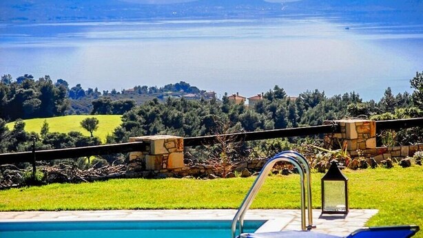 Un espace piscine offrant une vue sur un lac et des montagnes.