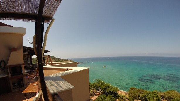 A balcony with a view of the sea and a distant boat. - Exclusive penthouse overlooking the sea ....... with deserted beach under the house. (Alghero)