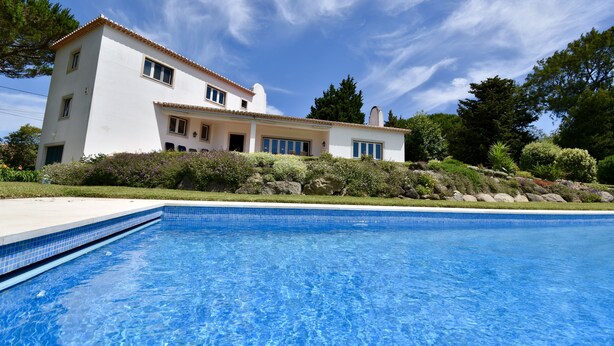 Une maison à deux étages avec une piscine à l’avant.
