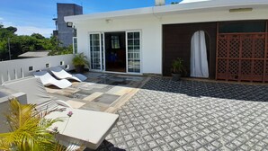Una casa moderna con patio, con sillones de descanso y piso estampado.