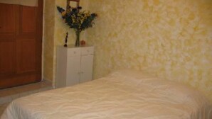 A bedroom with a bed, a dresser, and a wall-mounted cabinet. - Rochecolombe: Apartment/ flat - ROCHECOLOMBE (Rochecolombe)