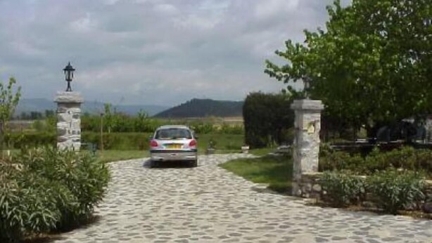 A paved driveway leading to a stone gate with a lamp post on the left. - Rochecolombe: Apartment/ flat - ROCHECOLOMBE (Rochecolombe)
