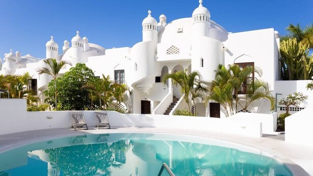 Un bâtiment blanc avec des toits en forme de dôme et une piscine.