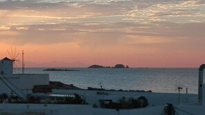A coastal view with a windmill, calm sea, and distant islands. - White Cycladic Desing House in the heart of Parikia sea vew (Parikia)