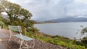 A bench overlooking a lake with a view of distant hills. - Exceptional House In Superb Location in NTS Conservation Area, Stunning Sea View (Kyle of Lochalsh)