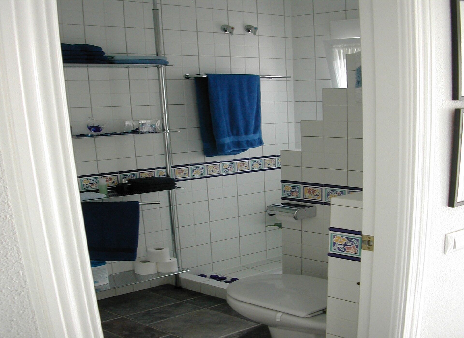 A small bathroom with a toilet, a shower, and a sink.