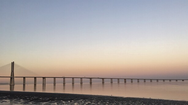 A long bridge over calm water during sunset. - LisbonMeetU - Flat in Parque das Nações | T1 (Sacavém)