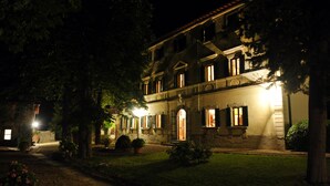 A historic building with multiple windows and a well-maintained garden at night. - An 800 villa in the Tuscan countryside - a quiet place - pool - culture (Londa)