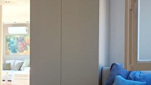 Ein modernes Wohnzimmer mit einer Couch, einem großen Kleiderschrank und einem Bild an der Wand.