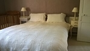 Ein Schlafzimmer mit einem großen Bett, zwei Nachttischen, einem Schrank und einem Kleiderschrank.