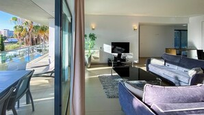 A modern living room with a TV, sofa, and dining area.