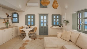 Un'ampia cucina con zona pranzo, una porta grigia e vista mare.