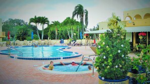 Ein Swimmingpool mit Liegestühlen und Palmen.