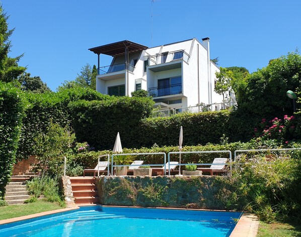 A modern two-story building with a swimming pool in the foreground.