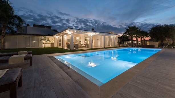 A modern house with a swimming pool, outdoor seating, and a well-lit patio area. - Villa Le Palme - Luxury Villa with pool (Ispica)