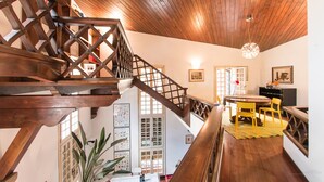 Una escalera de madera que conduce a un comedor con una mesa y sillas.