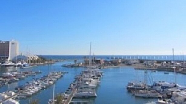 A marina with numerous boats docked, a clear sky, and a distant bridge. - Apartment in the solar sector of Dos Pinheiros, Vilamoura (vilamoura)