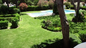A well-maintained garden with a swimming pool, neatly trimmed hedges, and a variety of trees. - Apartment in the solar sector of Dos Pinheiros, Vilamoura (vilamoura)