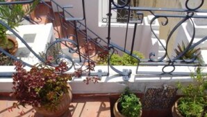 Een balkon met plantenbakken en een metalen hekwerk.
