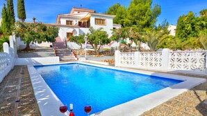 A swimming pool with a clear blue water, surrounded by white walls and a white fence. - Detached Villa El Tomillar in Frigiliana / Nerja (Frigiliana)