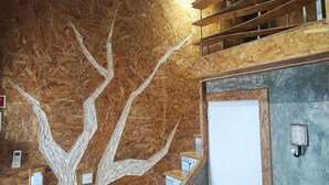 A room with a wooden tree mural on the wall, a staircase with wooden railings, and a door with a small sign. - Ruby Charm Houses 6 63367/AL (Porto)