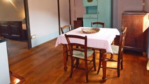 A dining area with a wooden table and chairs, a light blue cabinet, and a wooden floor. - Giglio: accommodation in an ancient 18th century farmhouse in the Santerno river valley (Firenzuola)