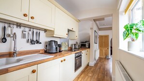 A modern kitchen with wooden countertops, white cabinets, and a variety of appliances including a coffee maker, toaster, and microwave. - Buckingham Townhouse -  a family break that sleeps 6 guests in 3 bedrooms (York)