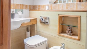 A compact bathroom with a skylight, a bidet, a sink, and a small shelf with decorative items. - Comfy Home.  No longer available on this site. No bookings accepted (Hamilton)