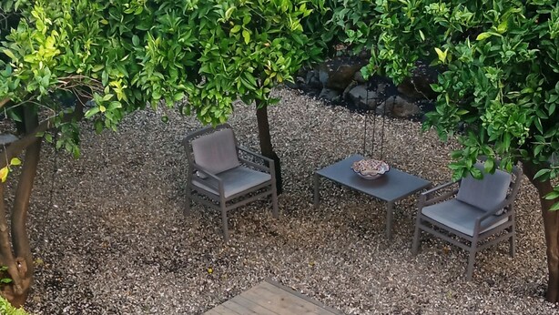 Un bain à remous entouré d’une terrasse en bois, avec une chaise et une table à proximité.