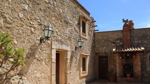 A courtyard with stone walls, a tiled floor, and a rustic building with a chimney. - BEAUTIFUL VILLA with SWIMMING POOL for EXCLUSIVE use, relax a few km from the sea! (Carini)