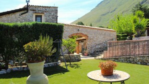 A stone building with a tiled roof, a small garden with a cactus and potted plants, and a table with a patterned tablecloth. - BEAUTIFUL VILLA with SWIMMING POOL for EXCLUSIVE use, relax a few km from the sea! (Carini)