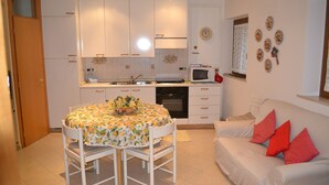 A compact kitchen with white cabinets, a microwave, and a dining table with chairs. - new renovated apartment 3 rooms - 2/5 persons, modern and well furnished. 8 minuts walk to S. Marco - (Venezia)
