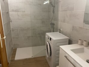 Regadera, secadora de cabello, toallas, papel de baño 