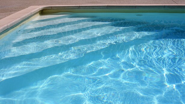 A clear swimming pool with visible water patterns and a concrete edge. - Apartment *** with terrace and swimming pool in secure luxury residence (Saint-Rémy-De-Provence)