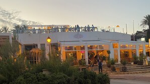 Een restaurant met terras, een overdekte patio en een verzorgde tuin.