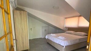Une chambre à coucher avec un lit, une armoire et une porte.
